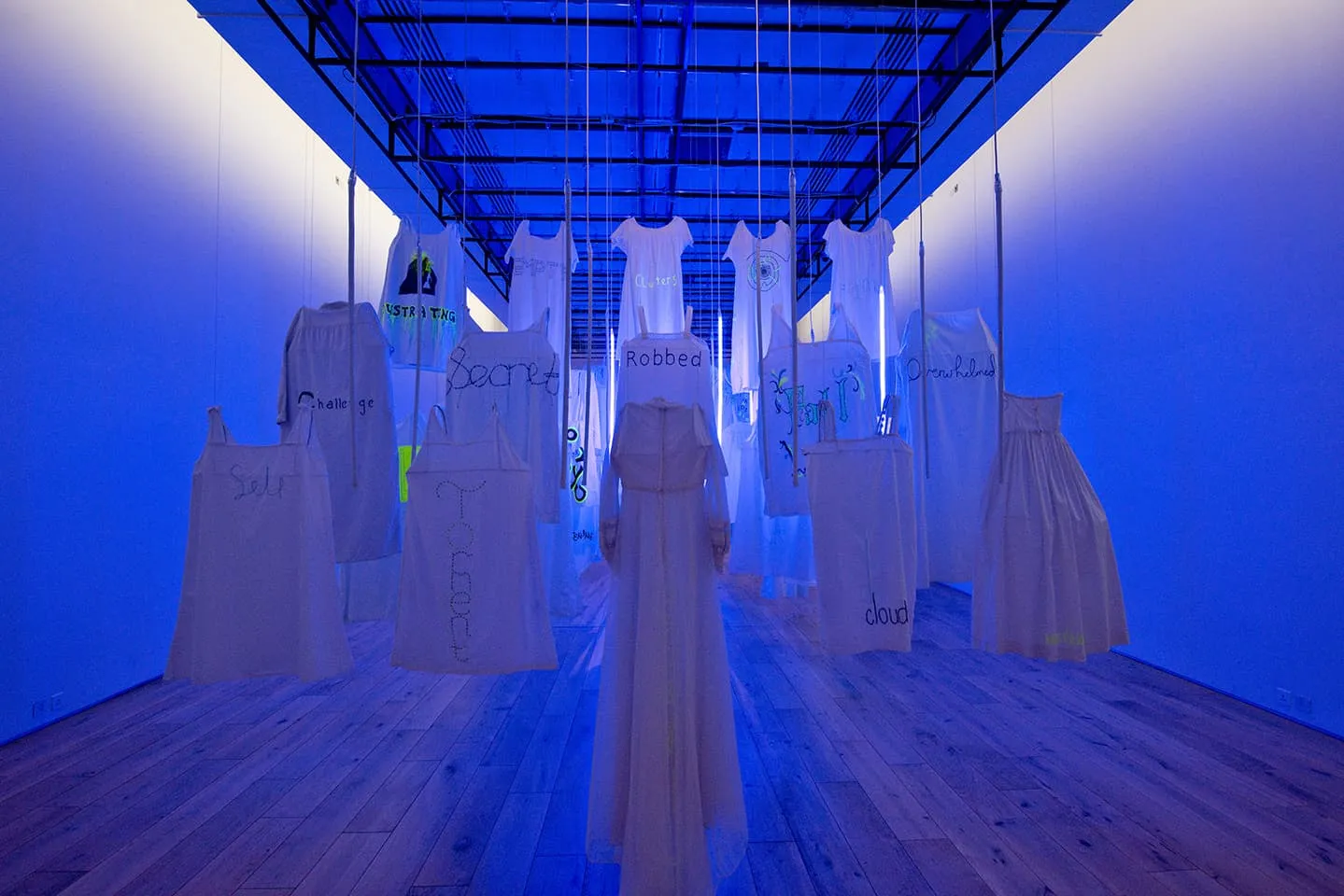 <strong>Out of the Blue</strong>, installation, from the back showing single word, with ultraviolet light, Susan Aldworth, 2020. Photograph by Colin Davison at Hatton Gallery.